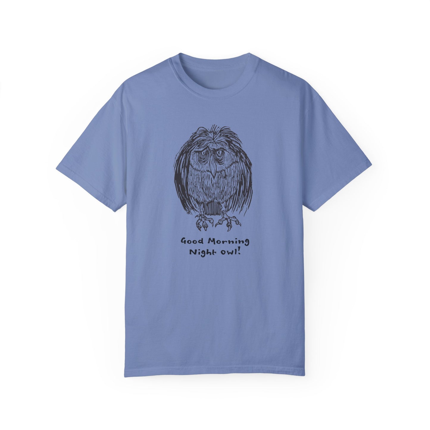 Blue or washed denim colored t-shirt featuring an illustration of a tired-looking owl with messy feathers, created from a linoleum block print. The owl stands with drooping eyes, and below it, the text reads: “Good Morning Night Owl!
