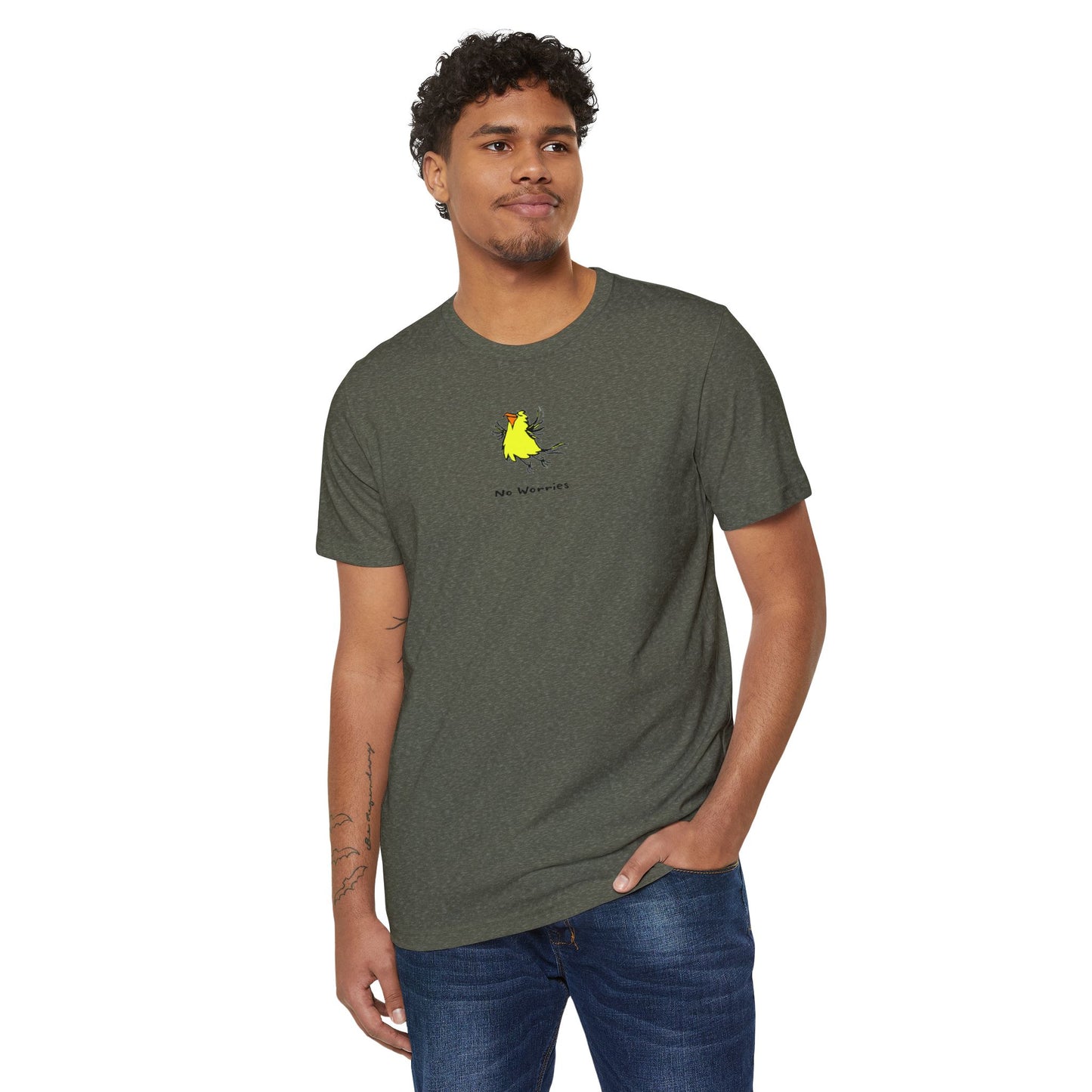 Man wearing a heather military green colored t-shirt featuring a small, centered linocut-style illustration of a happy looking flying yellow bird with an orange beak.  Below the artwork is the phrase “No Worries.”