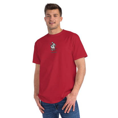 Man in pepper red organic unisex t-shirt featuring a playful, cartoon-style dog with one ear raised and a wagging tail, with the caption “Who Me?” printed below—a fun eco-friendly graphic tee for dog lovers.